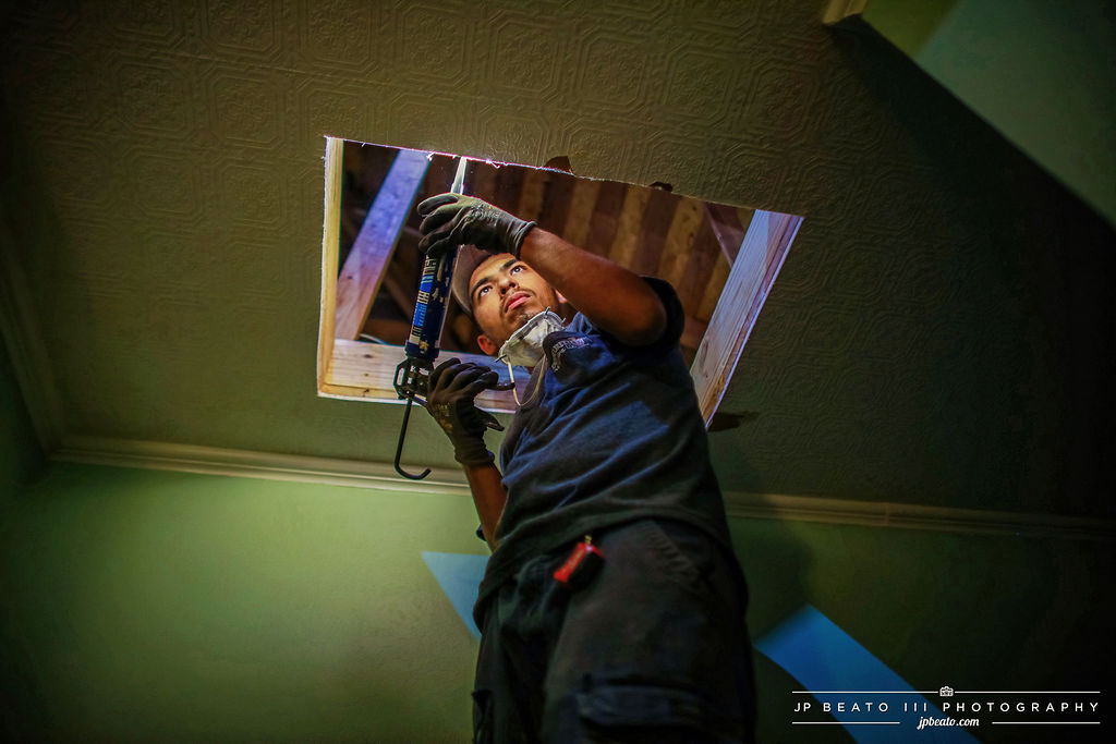 Integrity 1st technician working on a ceiling HVAC opening